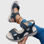 Close-up top view of black sandal showing perforated footbed texture and touch-strap buckle