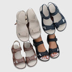 Brown sandals paired with distressed denim, side view showing full silhouette and sole thickness