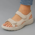 Side profile of beige adjustable strap sandal showing cut-out detailing and thick comfort sole