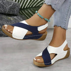Side view of navy and white crisscross strap wedge sandals showing stitched platform sole