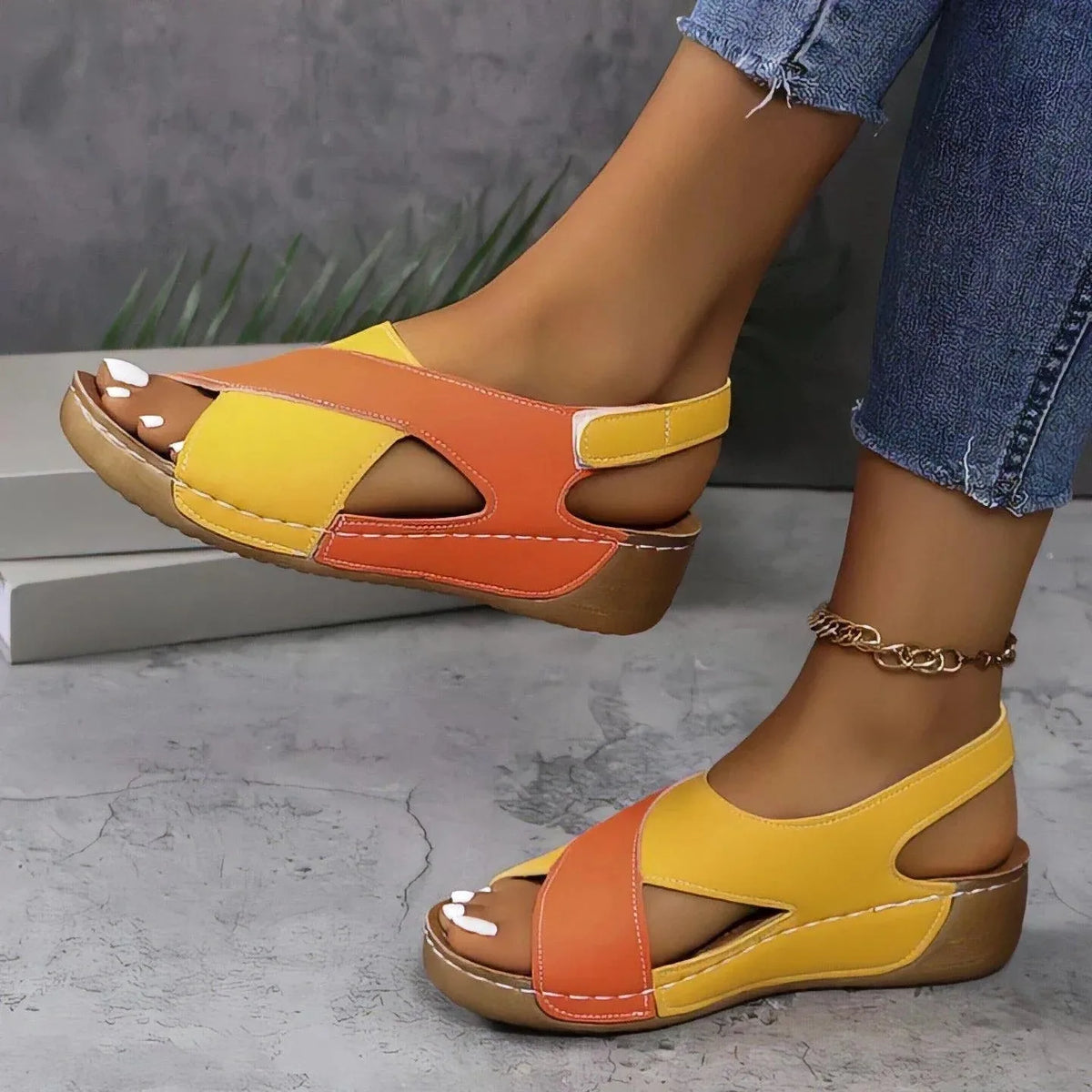 Front angle of yellow and orange wedge sandals highlighting the cushioned stitched footbed