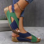 Side view of yellow and orange crisscross sandals worn with cropped denim jeans