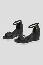 Black glitter wedge sandals with ankle strap, open toe and woven espadrille-style platform sole, side angle