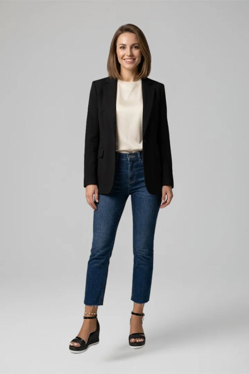 Model wearing black blazer, cream top and jeans styled with black glitter platform wedge sandals