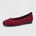 Side angle of a burgundy knit ballet flat with subtle sheen and black flat sole