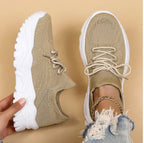 Side-by-side view of a beige knit sneaker with white chunky sole, one held by hand and one worn on foot with ripped jeans