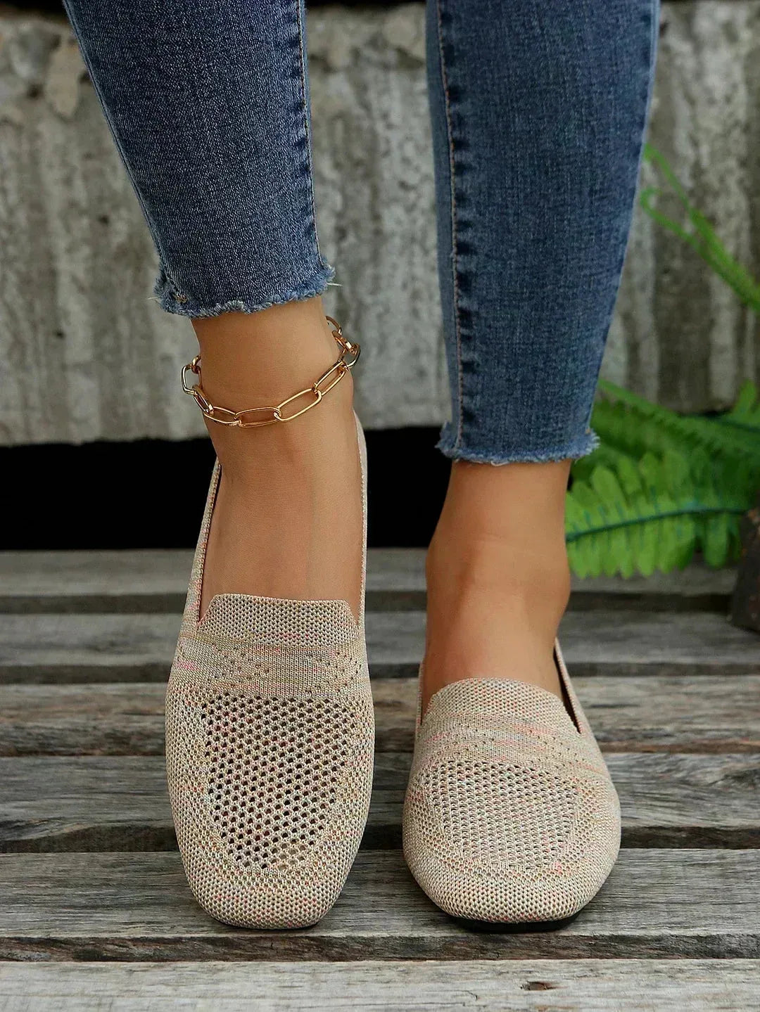 Side profile of a knit loafer showing low stacked heel and soft rounded toe shape