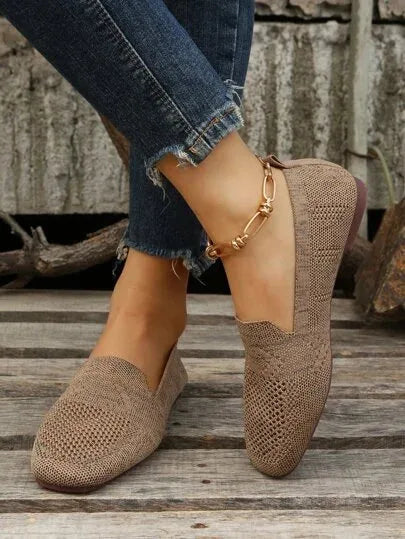 Beige mesh knit loafers worn with cropped jeans, styled with a gold ankle chain on wooden steps