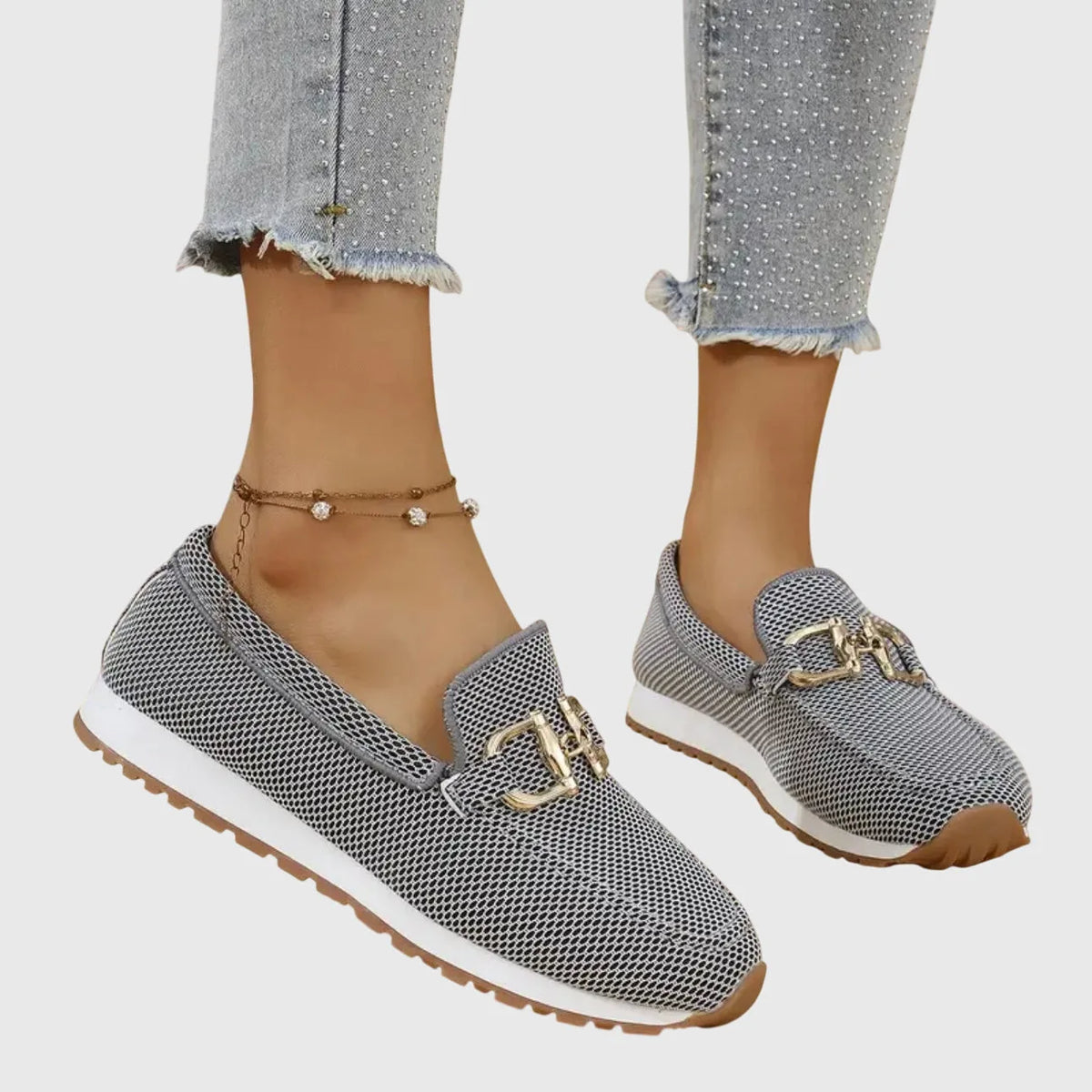 Blue knit slip-on loafer with gold buckle detail worn on foot, shown from a close front angle