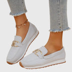 Front close-up of a white knit slip-on loafer on a model's foot showing the ribbed knit texture