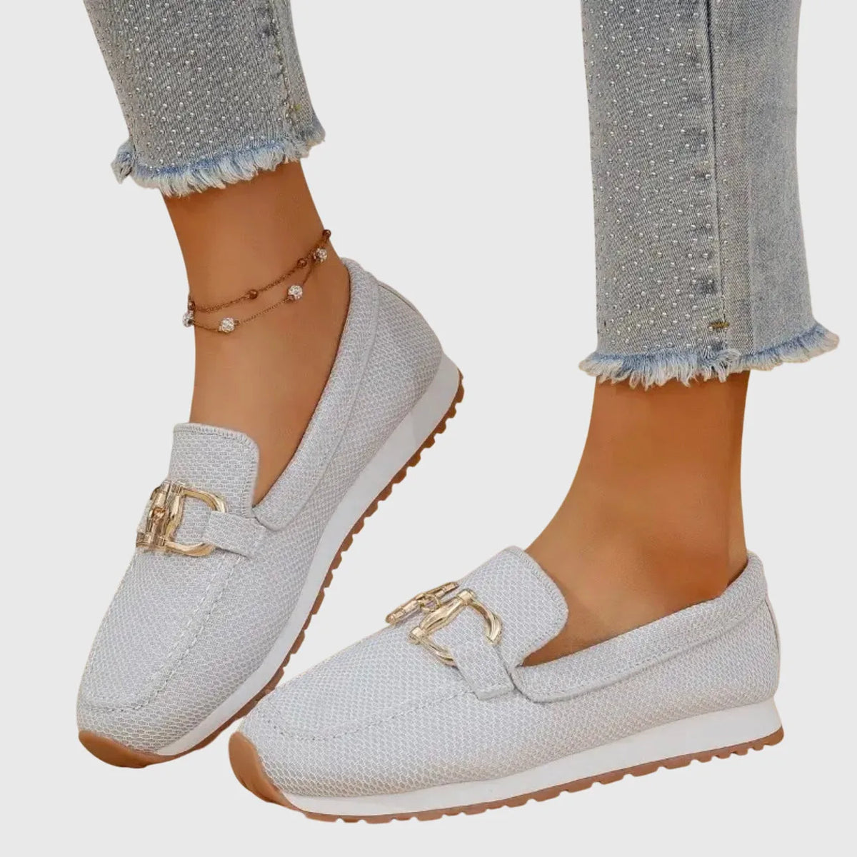 Front close-up of a white knit slip-on loafer on a model's foot showing the ribbed knit texture