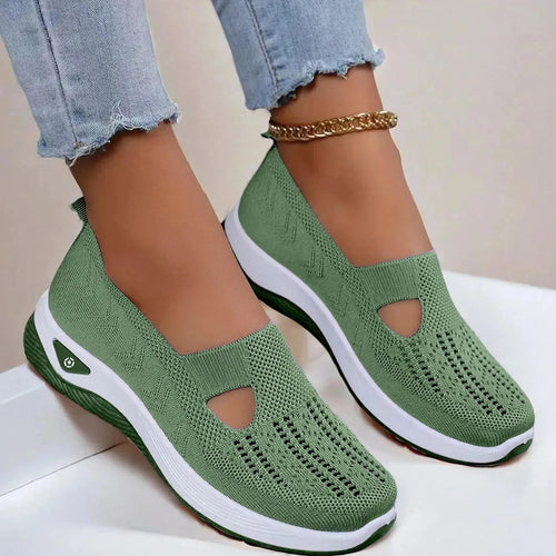 Side view of army green knit slip-on shoes with cut-out detail and white platform sole, worn with cuffed denim jeans