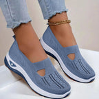 Front angled view of grey knit slip-on shoes showing the round toe box, elastic entry and grippy ridged outsole