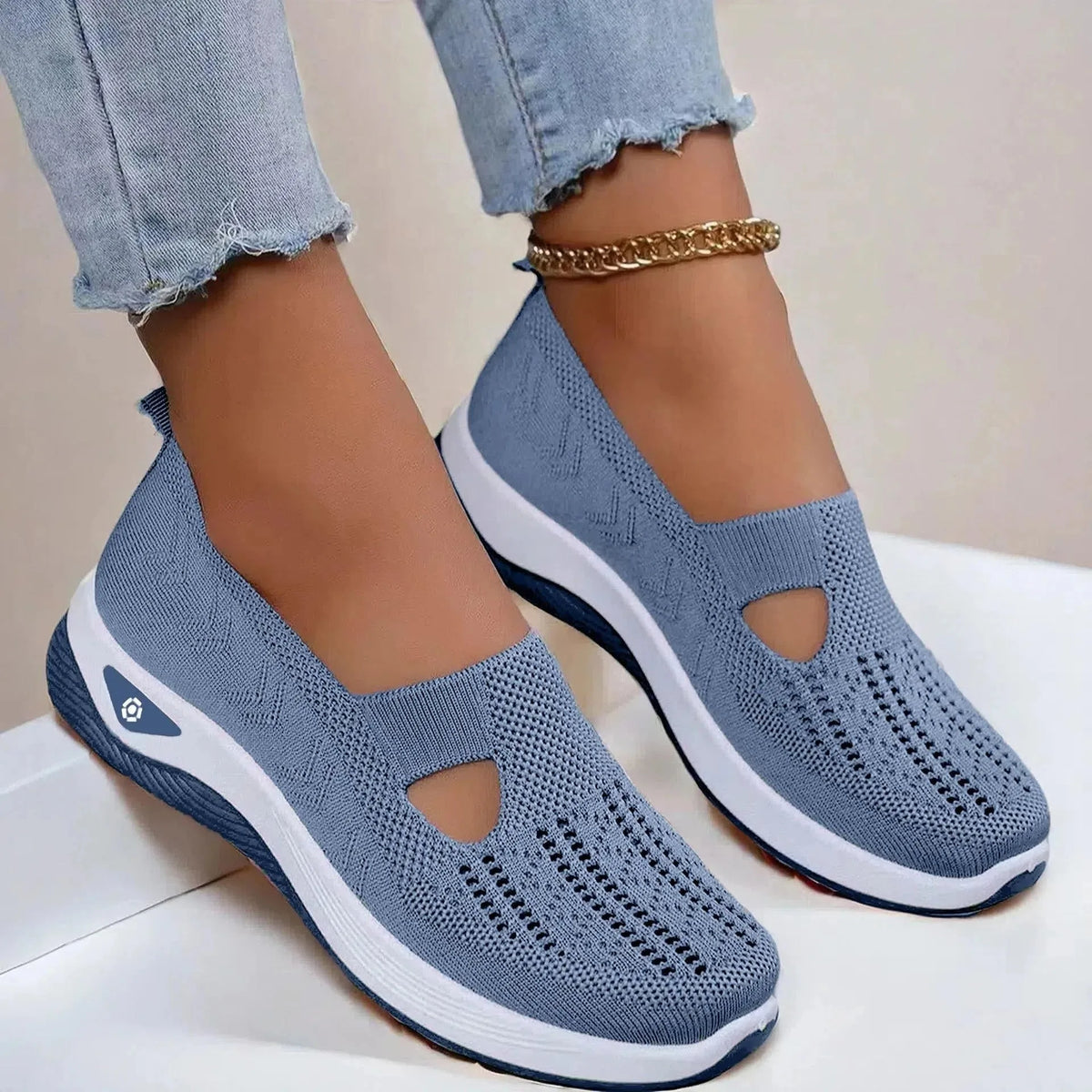 Front angled view of grey knit slip-on shoes showing the round toe box, elastic entry and grippy ridged outsole