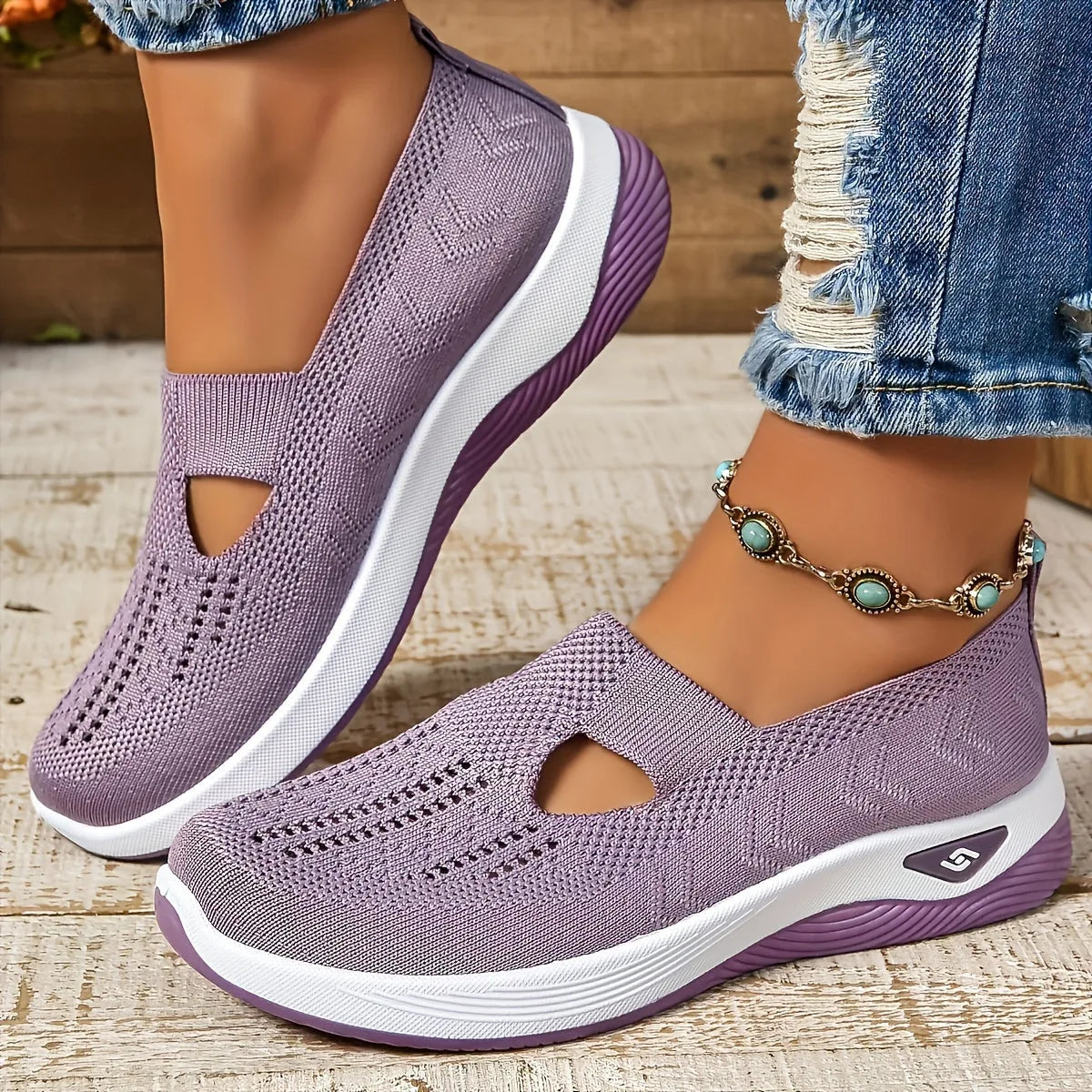 Angled view of lilac mesh slip-on shoes with cut-out vamp detail and matching lilac rubber outsole against a wooden backdrop