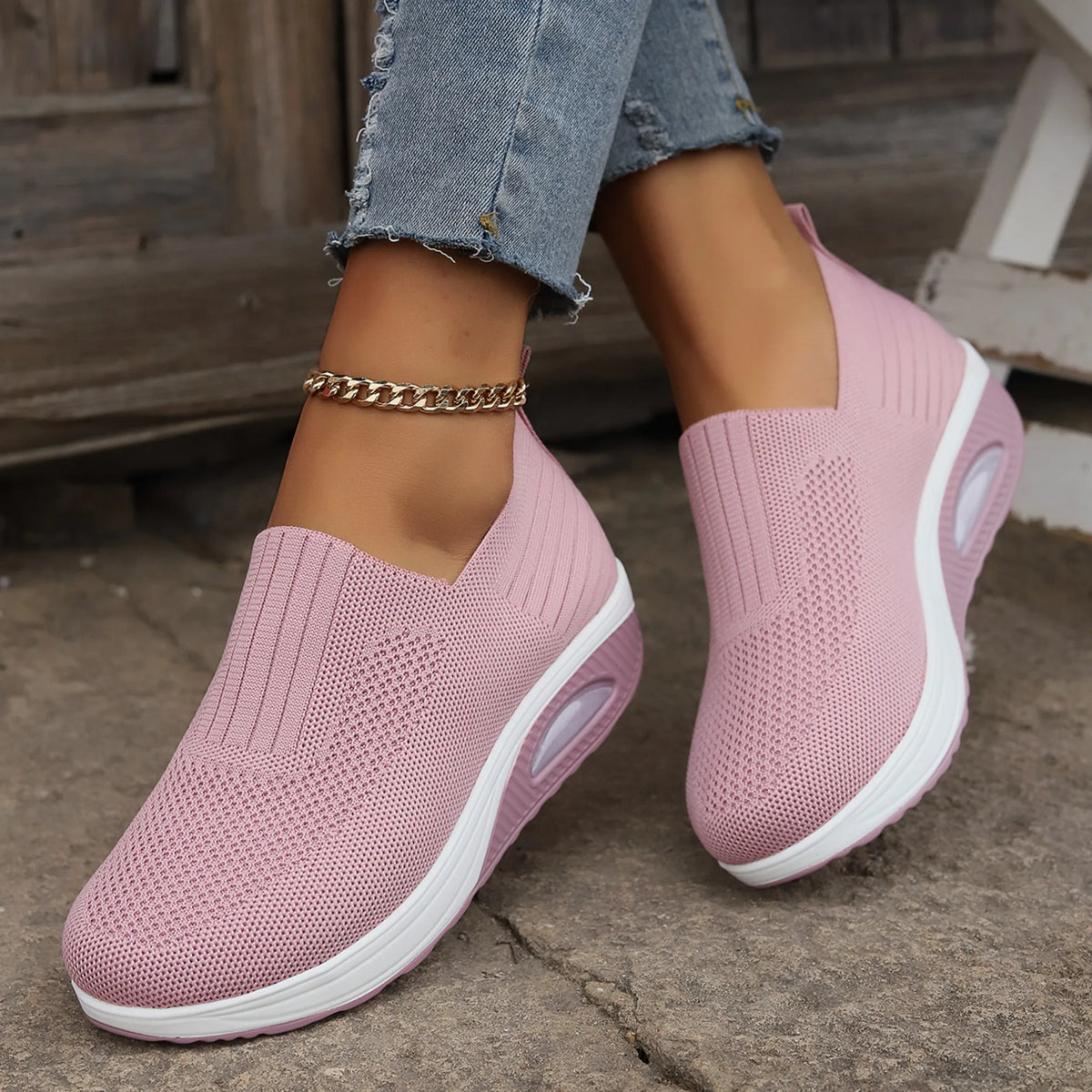 Pink knit slip-on sneakers worn on feet, angled view showing breathable mesh texture and platform sole