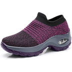 Navy blue knit sneaker with a white midsole, black outsole and ribbed ankle cuff