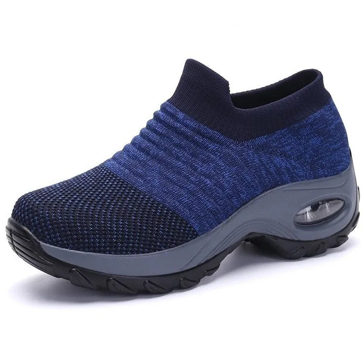Close-up side view of a black slip-on knit sneaker highlighting the sock-like ribbed upper