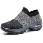 Black knit sneaker with a grey rubber sole and visible air cushion unit in the heel