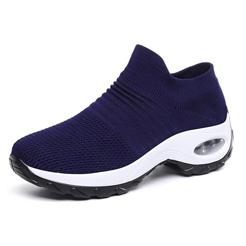 Side profile of an all-white knit sneaker with matching white ribbed sole and air cushion