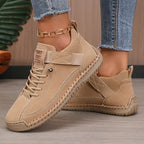 Beige suede-look sneaker with woven lace detail and matching cream outsole on model's foot