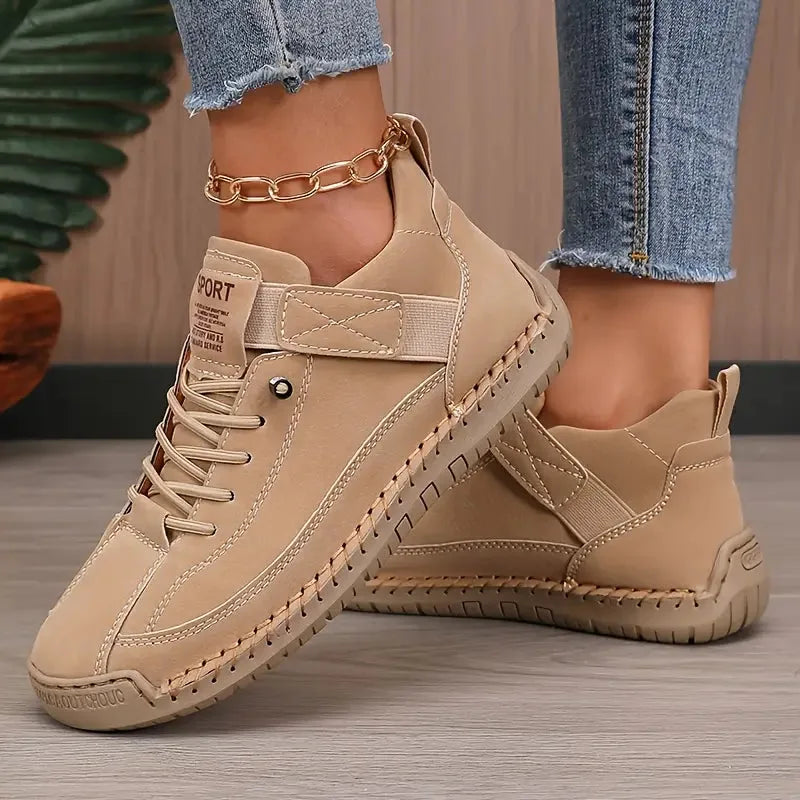 Beige suede-look sneaker with woven lace detail and matching cream outsole on model's foot
