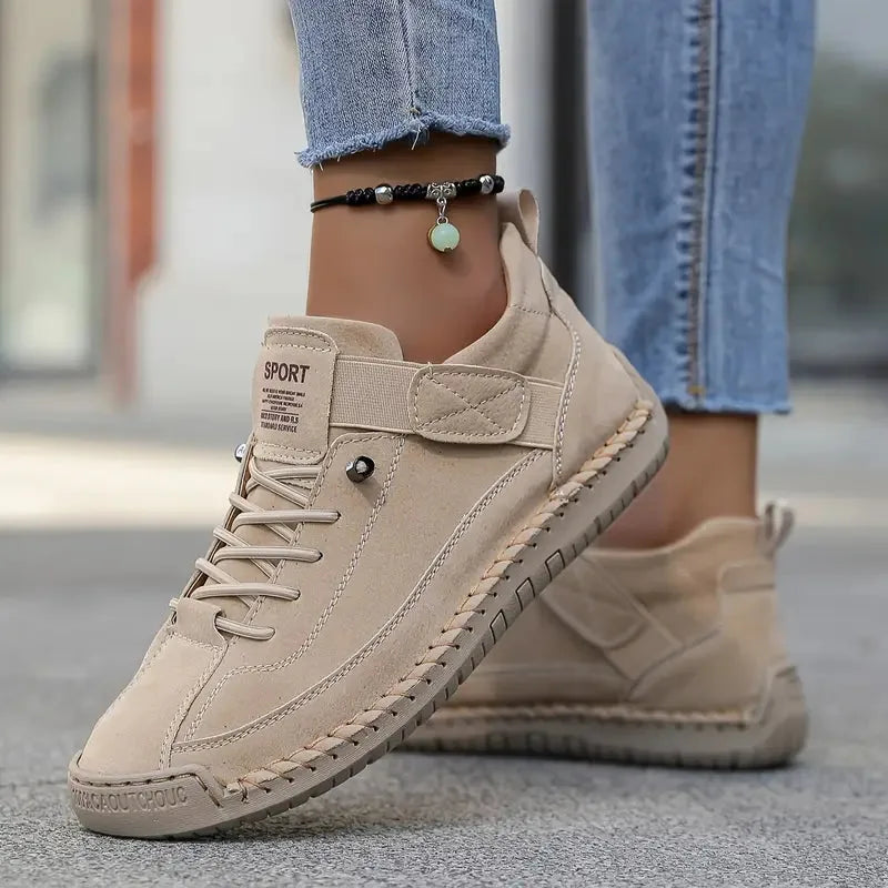 Taupe suede sneaker with black beaded anklet, showing elastic side panel and ribbed sole