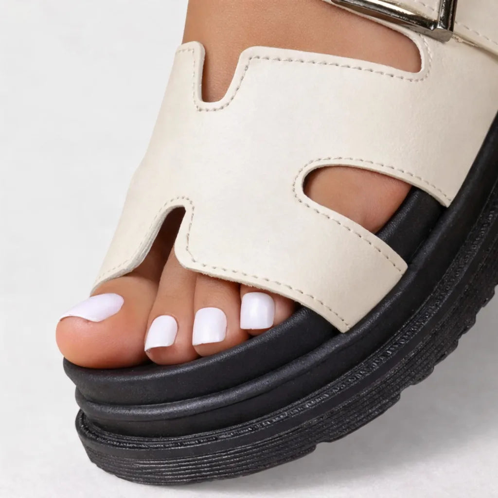 Close-up of chunky platform sole and cream cut-out strap detail showing stitching and ridged outsole texture