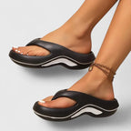 Side profile of black thong-strap platform sandal with white wavy midsole accent worn on foot