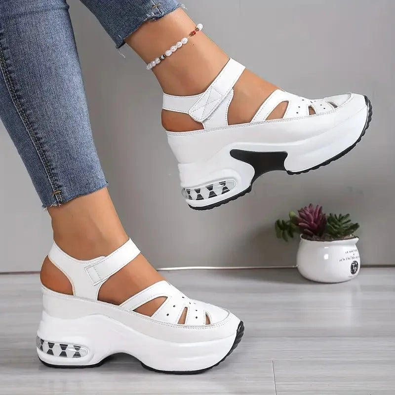 Pair of white chunky platform sandals viewed from above, showing the quilted strap and closed toe cap