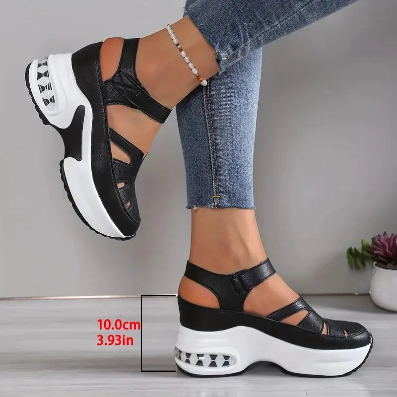 Black platform sandal with white sole labelled 10cm wedge height, showing cut-out ankle straps