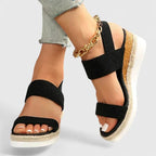 Front angled view of black espadrille wedge sandals showing toe strap and jute-wrapped platform