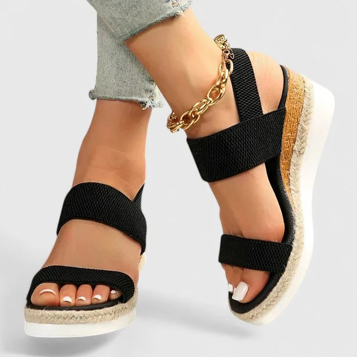 Front angled view of black espadrille wedge sandals showing toe strap and jute-wrapped platform
