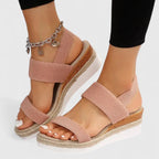 Dusty pink wedge sandals with crossover straps and espadrille platform, paired with black leggings