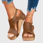 Back view of black wedge sandals showing tread pattern on the sole and adjustable strap closure