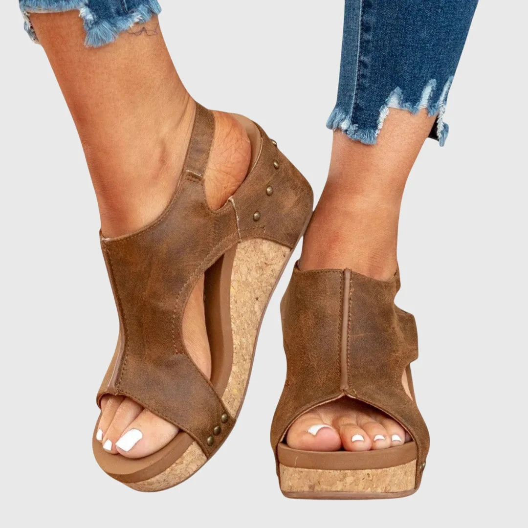 Back view of black wedge sandals showing tread pattern on the sole and adjustable strap closure