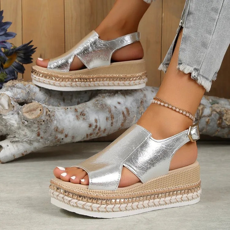 Side view of metallic silver wedge sandal with cutout upper and woven espadrille-style platform sole