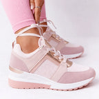 Pink and rose gold wedge sneaker with mesh panelling and lace-up front, worn with cropped leggings