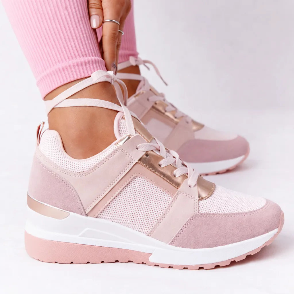 Pink and rose gold wedge sneaker with mesh panelling and lace-up front, worn with cropped leggings
