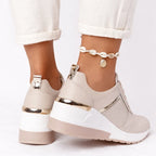 Back view of beige wedge sneakers showing gold heel pull tabs and two-tone cream and beige sole