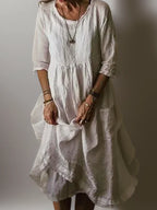 Off-white linen midi dress close-up showing fabric texture and three-quarter sleeve cuff