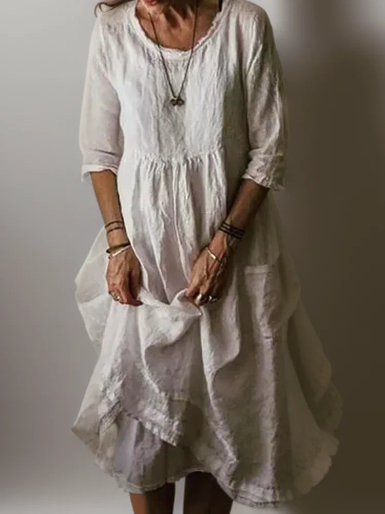 Off-white linen midi dress close-up showing fabric texture and three-quarter sleeve cuff