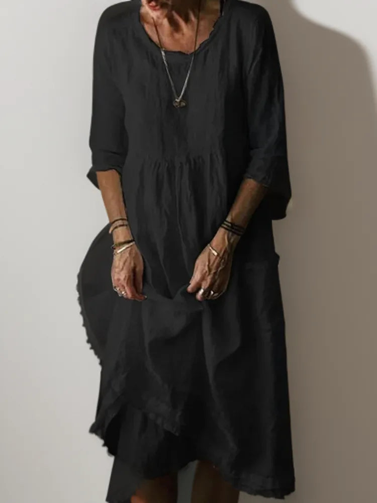 Black linen midi dress showing raw-edge neckline and loose A-line silhouette