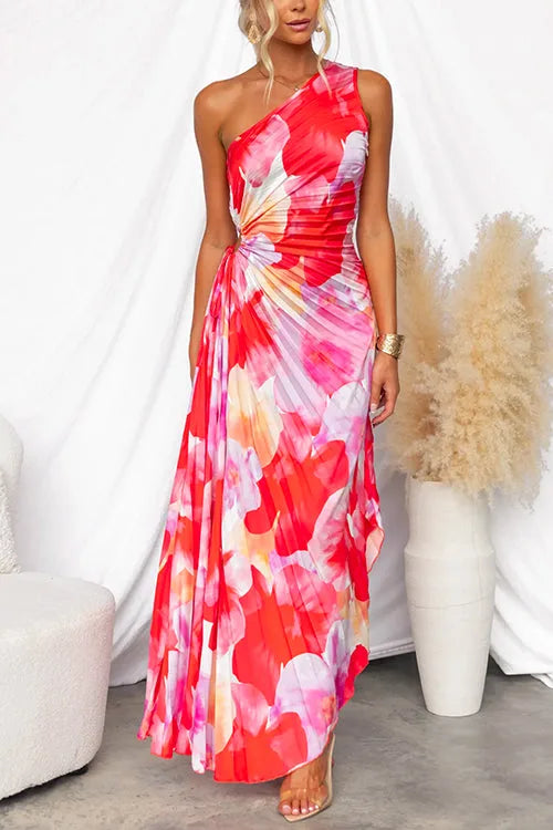 Front view of a one-shoulder red and pink floral print pleated maxi dress with ruched waist detail
