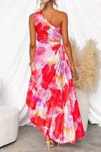 Back view of the one-shoulder floral maxi dress showing the pleated skirt and asymmetric hemline