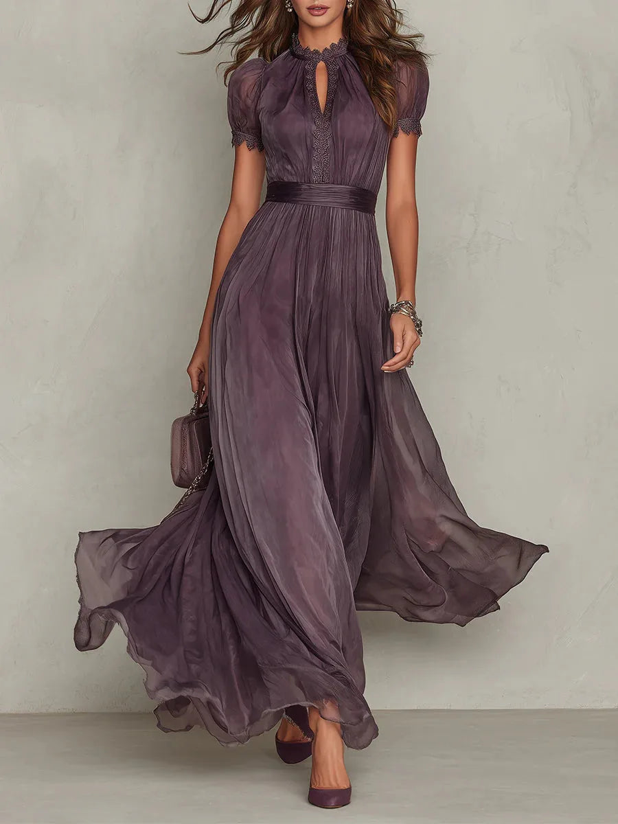 Front view of a model walking in a flowing plum high-neck maxi dress with short sleeves and a keyhole neckline