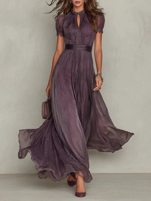 Front view of a model walking in a flowing plum high-neck maxi dress with short sleeves and a keyhole neckline