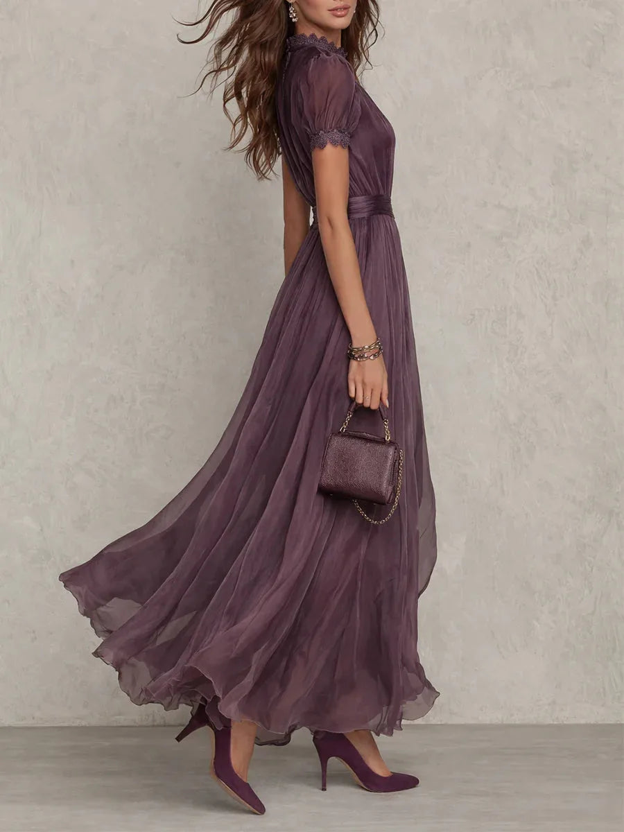 Side view showing the dress's slim waist sash and the sweeping movement of the pleated chiffon skirt
