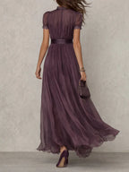 Back view of the plum maxi dress highlighting the high neckline, lace trim and flowing silhouette