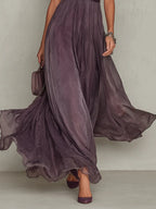 Close-up of the flowing pleated skirt in motion, showing the soft ombre plum tone and sheer chiffon layers